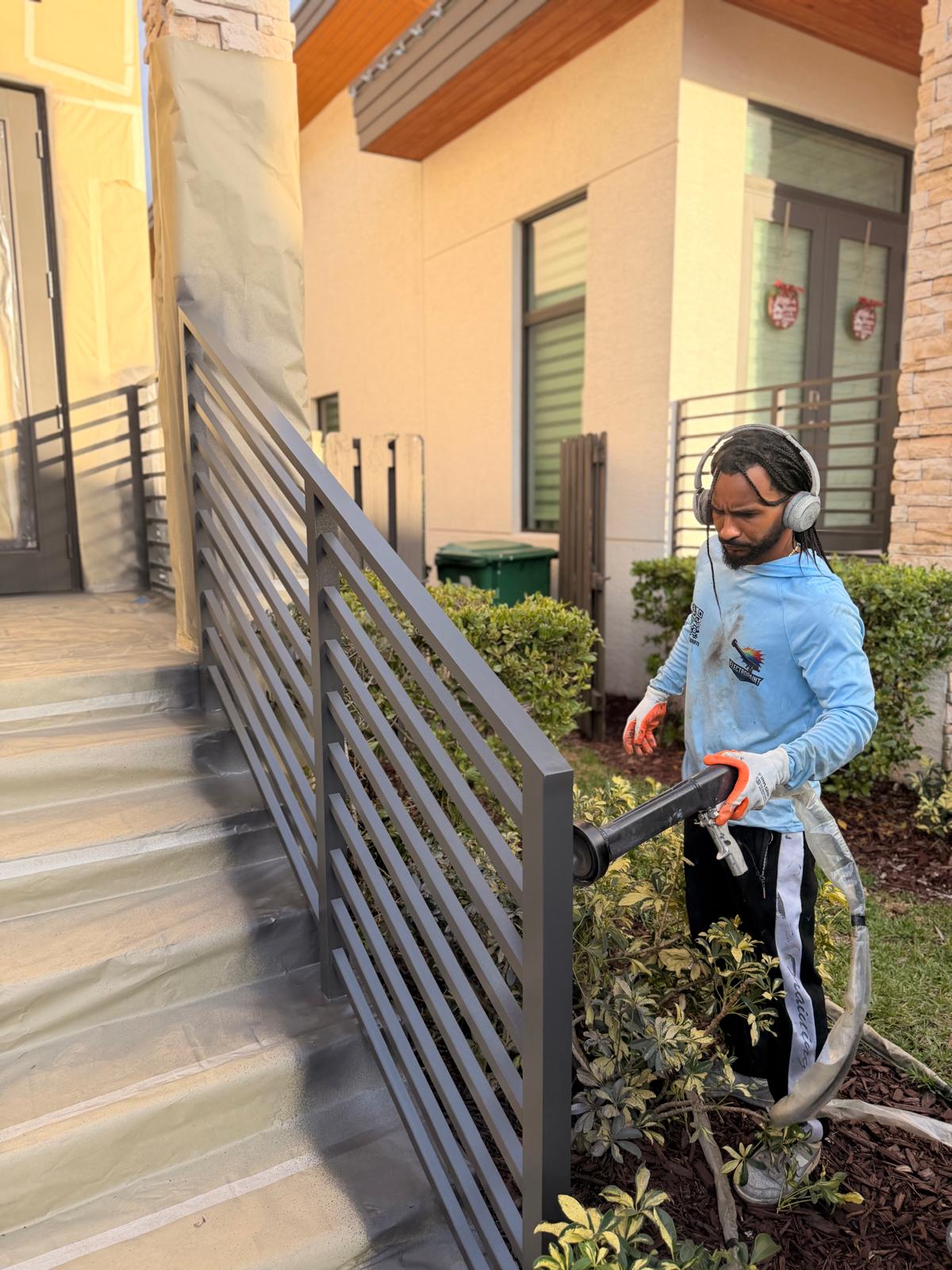 Electrostatic coating being applied to an installed metal driveway gate in South Florida