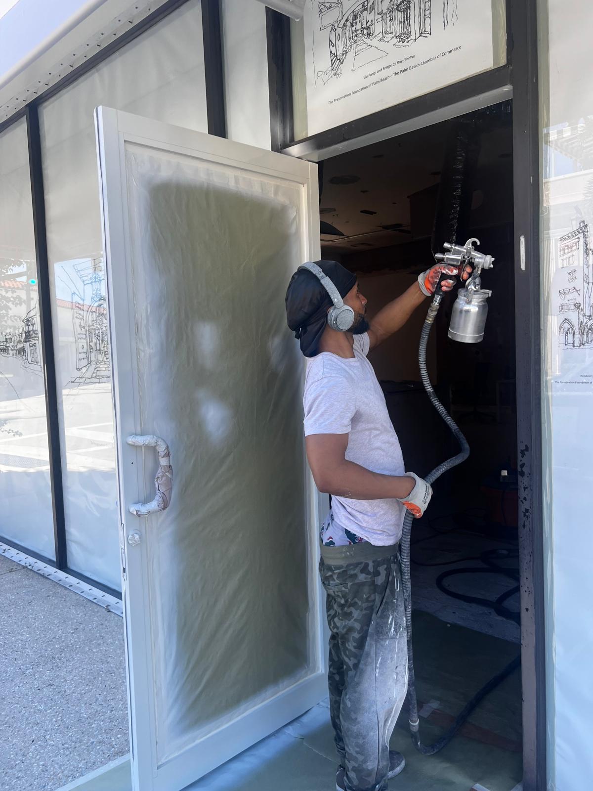 Commercial storefront door frame being refinished with a dark electrostatic coating