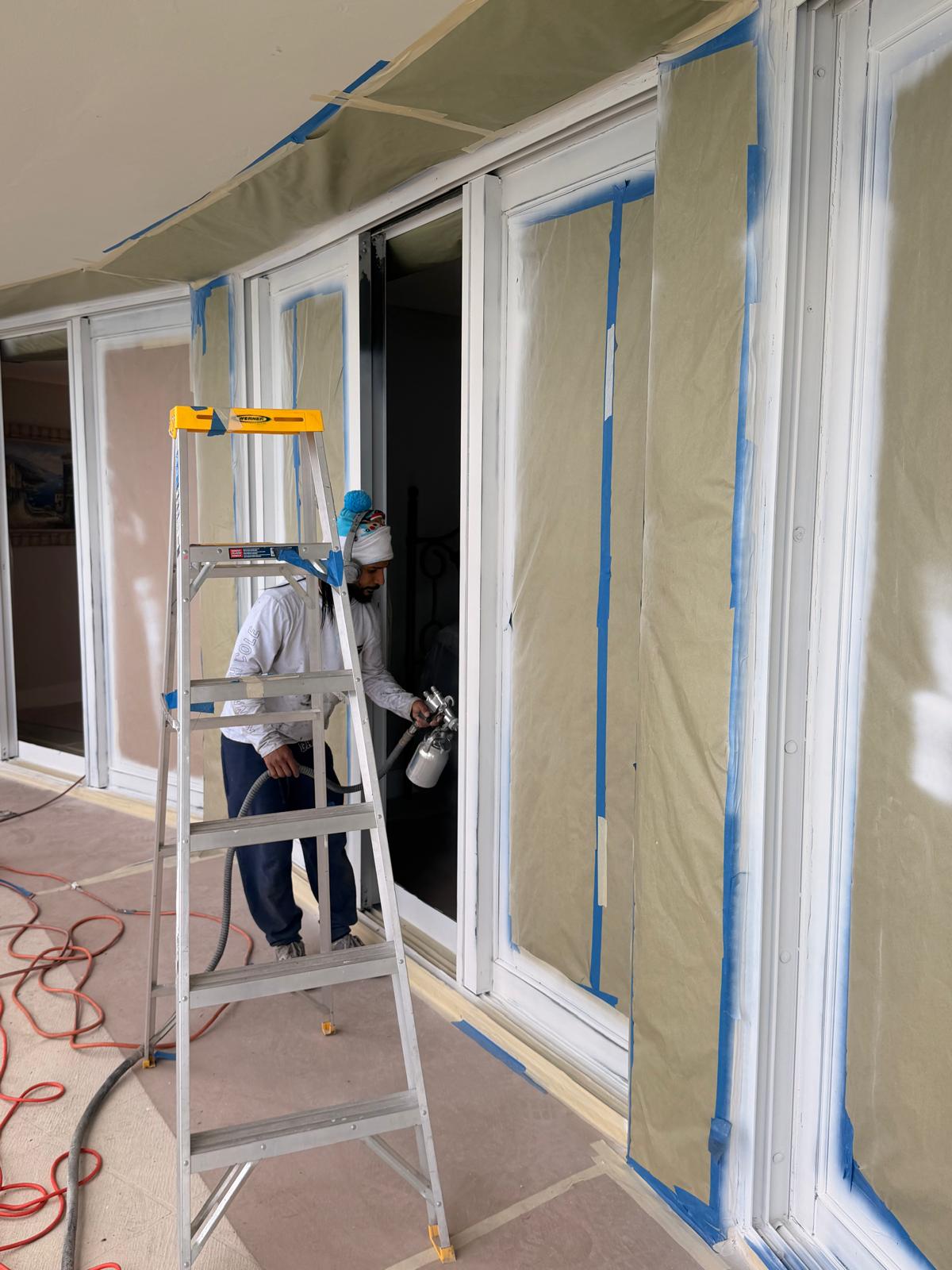 Crew sanding and preparing installed metal before primer is applied